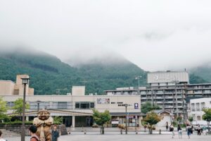 Buildings and misty mountains in a town square.